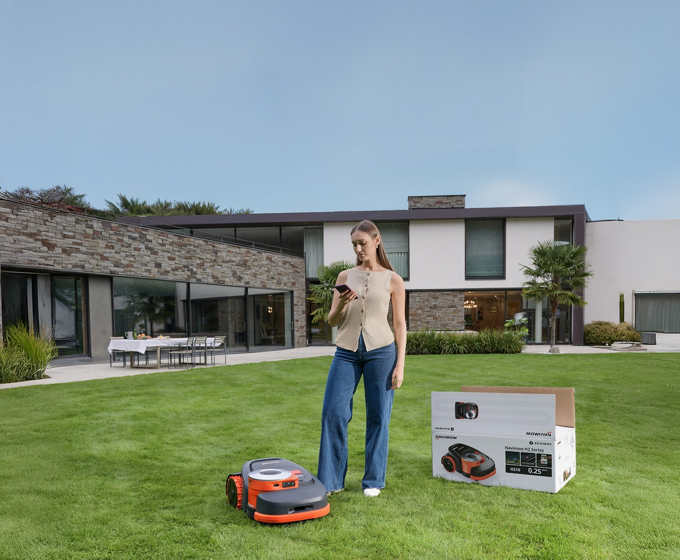 Navimow i110N robot lawn mower on grass with a woman.