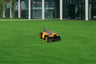 A Navimow i110N robot lawn mower on a green field.